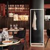 Free standing clothes rack made from white iron pipes for jackets from guests in restaurant